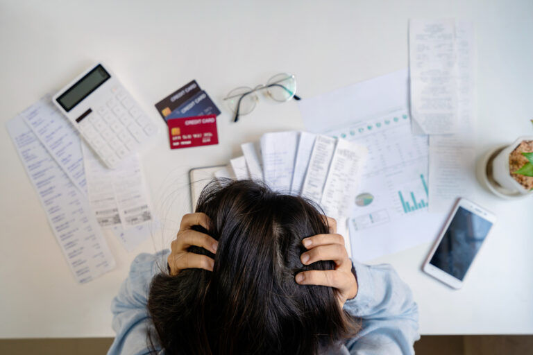 Stressed young woman calculating monthly home expenses, taxes, bank account balance and credit card bills payment, Income is not enough for expenses